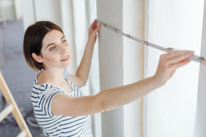 woman measuring for windows